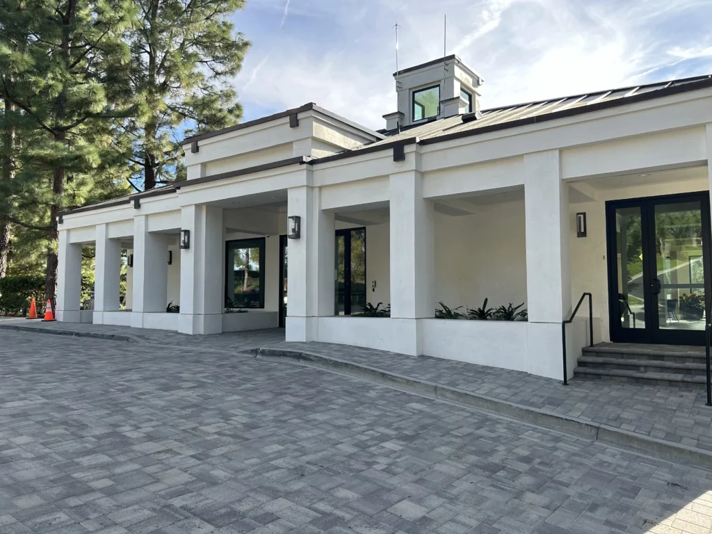Modern building exterior with columns and paved walkway.
