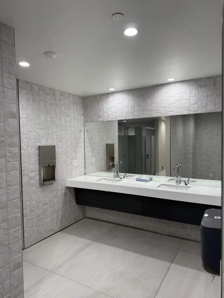 Modern bathroom interior with double sinks and large mirror.