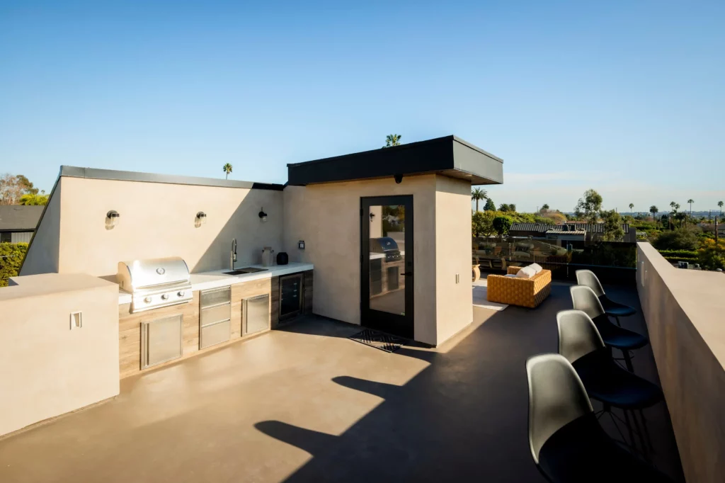 Modern rooftop kitchen with grilling area and seating