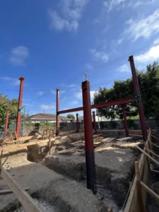 Construction site with steel beams and excavation under blue sky