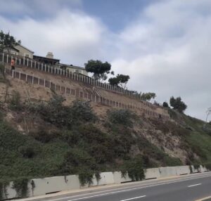 Person walking near hillside homes and lush greenery