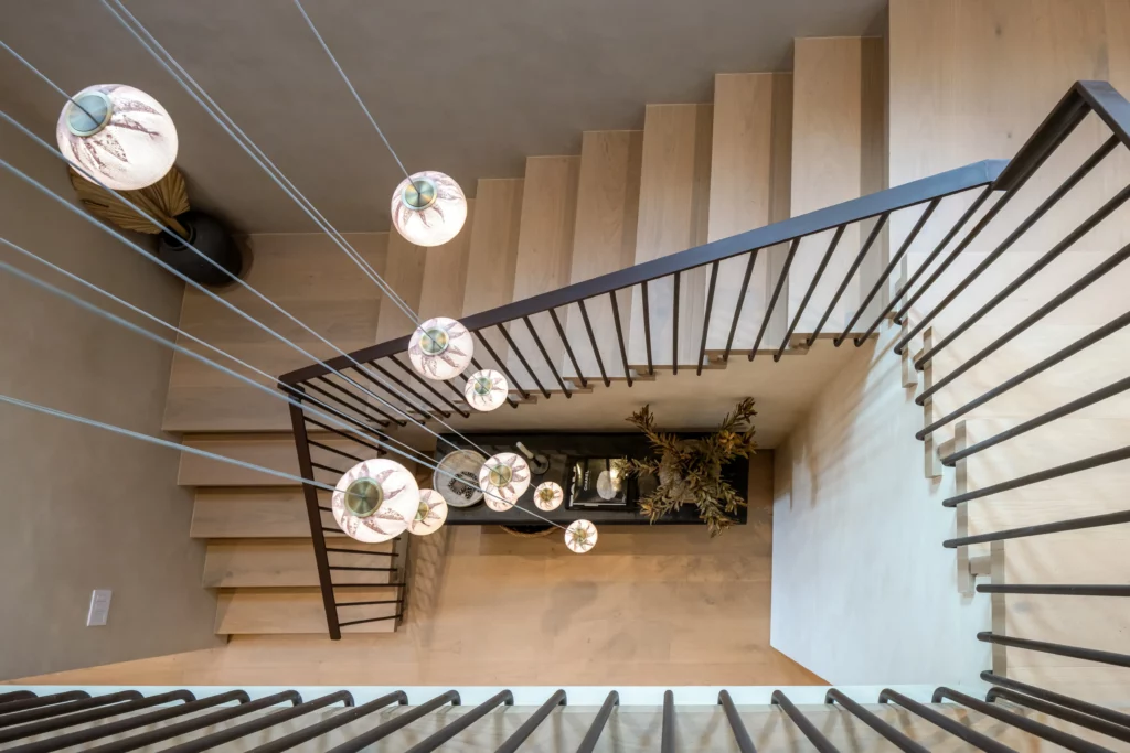 Modern staircase with decorative hanging lights and wooden steps