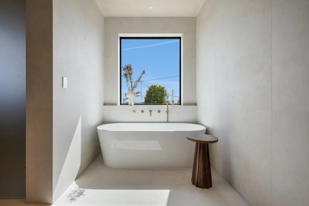 Minimalist bathroom with freestanding tub and scenic window view
