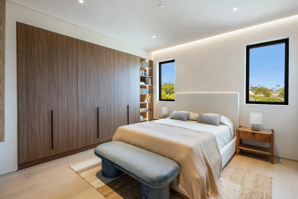 Modern bedroom with large bed, wooden accents, and view