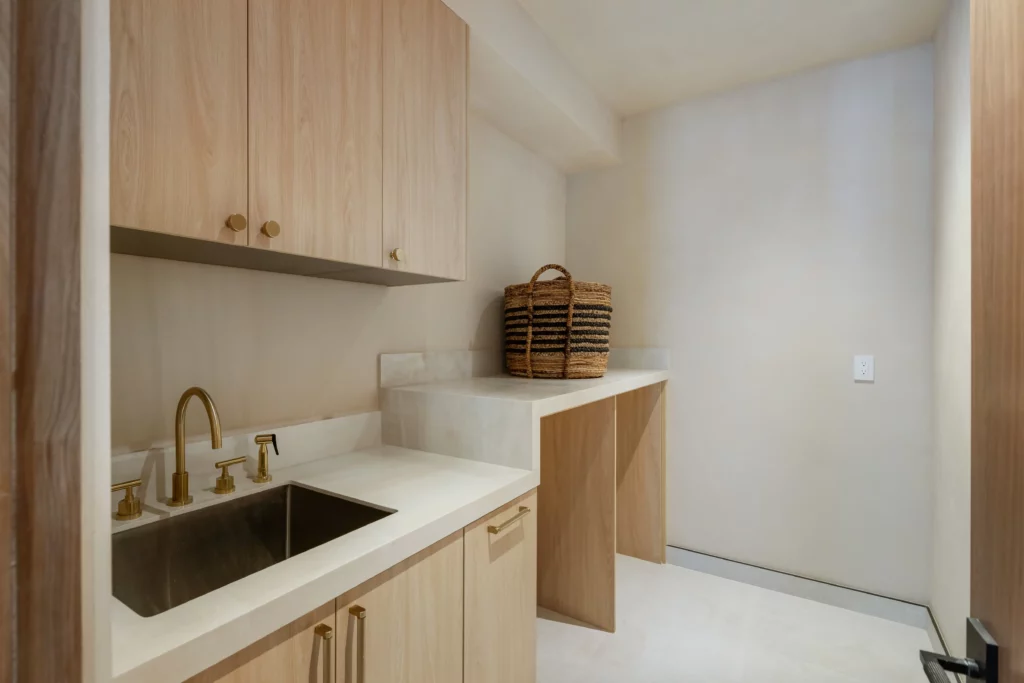 Modern minimalist laundry room with wooden cabinets