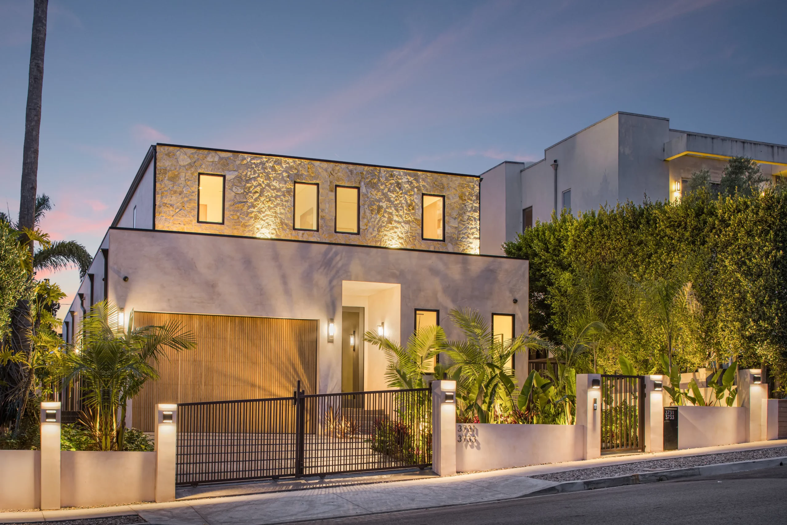 Modern house exterior at twilight with illuminated windows
