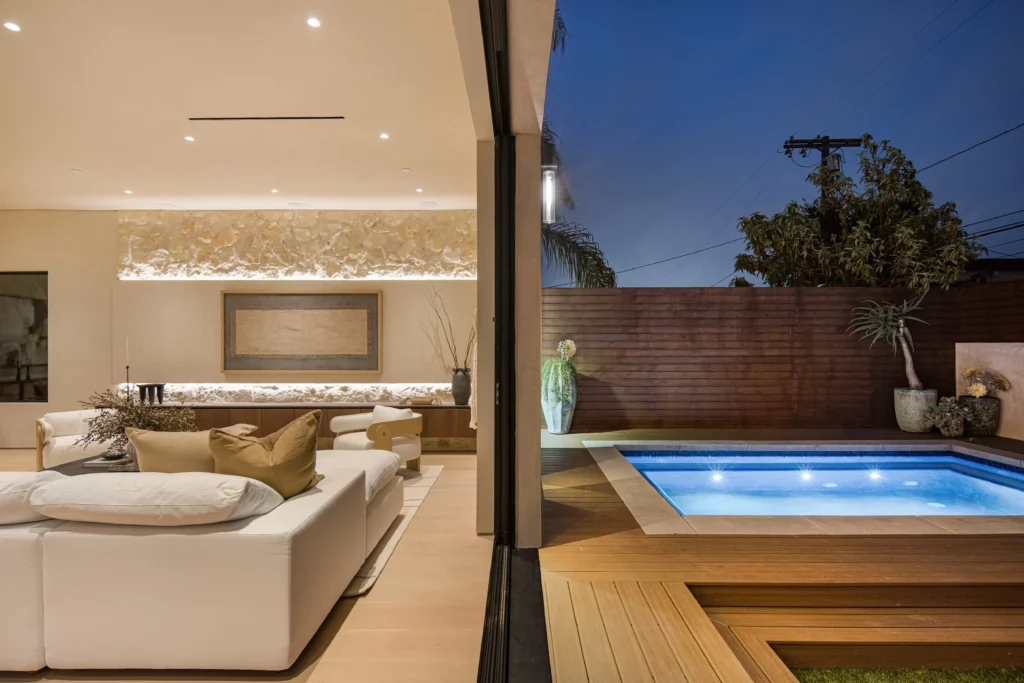 Luxurious modern living room next to outdoor pool at night