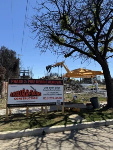 Construction site with debris removal sign under tree